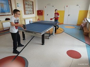 Dwójka uczniów gra w tenisa stołowego.
