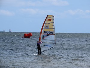 Uczennica płynie na desce windserfingowej.