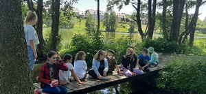 Uczniowie z klasy 6c siedzą na ławeczce w Gaju Świętopełka.