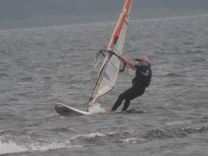 Uczennica Kalina Szostek na desce windsurfingowej na jeziorze.