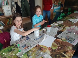Uczennice przy stole wykonują prace plastyczne w siedzibie Kaszubskiego Parku Krajobrazowego.