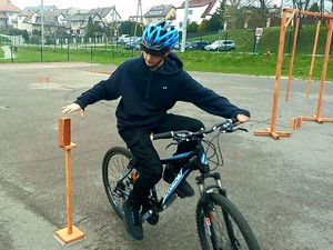Uczestnik powiatowych eliminacji BRD przejeżdża na rowerze przez jedną z przeszkód toru przeszkód.