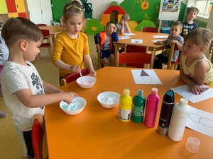 Dzieci z oddziału przedszkolnego (5 latki) wykonują przy stole prace plastyczne.