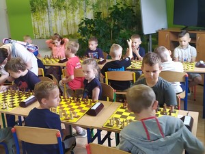 Uczennica Maja Wesołowska siedzi przy stoliku i gra w szachy.