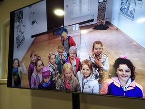 Uczniowie z klasy 1b w Muzeum Kaszubskim na ekranie monitora.