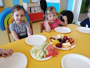 Dwoje dzieci z oddziału 4 latków siedzi przy stoliku przed rozpoczęciem pracy nad kompozycją owocową.