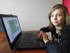 Uczeń "Dwójki" przed komputerem gra w szachowym turnieju online.