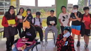 Uczniowie z zaprzyjaźnionej szkoły w Chile stoją i prezentują kartki z Polski.