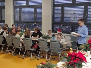 Uczniowie - przedstawiciele Samorządu Uczniowskiego siedzą przy stołach podczas wigilii Samorządu Uczniowskiego oraz Szkolnego Koła Wolontariatu "Serce".