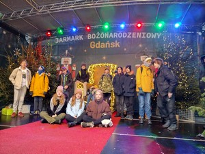 Uczniowie klasy 8a i 8c prezentują się do zdjęcia na scenie Jarmarku Bożonarodzeniowego w Gdańsku.