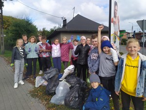 Uczniowie prezentują się do zdjęcia wraz z zebranymi śmieciami po zakończeniu akcji "Sprzątanie Świata".