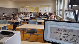 Uczniowie uczestniczący w Szkolnym Konkursie "Mistrz Pamięci Liczby Pi" siedzą przy stolikach i piszą liczbę Pi.