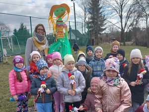 Dzieci z oddziału przedszkolnego (zerówka 02) wraz z wychowawczynią i postacią Marzanny prezentują się do zdjęcia.