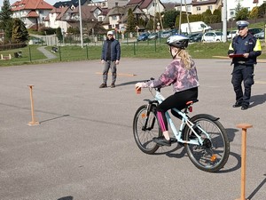 Uczennica uczestnicząca w gminnych eliminacjach Ogólnopolskiego Turnieju BRD jedzie na rowerze po torze przeszkód.