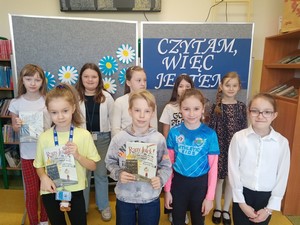Uczniowie biorący udział w szkolnym etapie Konkursu Pięknego Czytania "Czytam, więc jestem" prezentują się do zdjęcia.