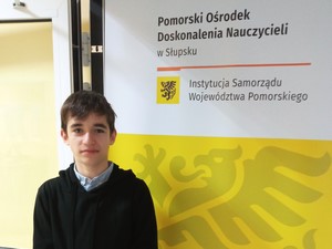 Uczeń Franciszek Nowak (8a) prezentuje się do zdjęcia na tle banera ODN w Słupsku.