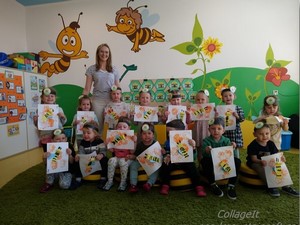 Dzieci z oddziału przedszkolnego (3 - latki) wraz z wychowaczynią prezentują się do zdjęcia.