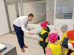 Pracownik Banku PKO wręcza dzieciom z oddziału przedszkolnego 4 latków prezenty.
