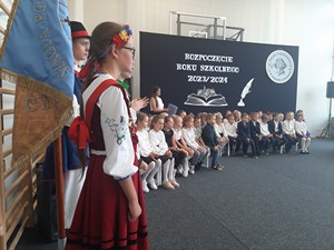 Uczniowie z pocztu sztandarowego stoją podczas apelu z okazji inauguracji roku szkolnego 2023 / 2024.