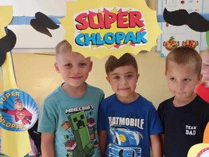 Trójka chłopców prezentuje się do zdjęcia w "fotobudce".