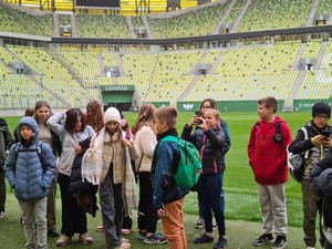 Uczniowie klas 6 stoją na płycie stadionu podczas wycieczki do Gdańska.