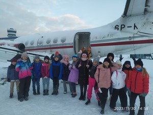 Uczniowie klasy 3b stoją przed samolotem na lotnisku w Gdańsku.