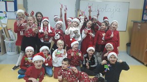 Dzieci z klasy 1c prezentują się w świątecznym, mikołajkowym ubiorze.