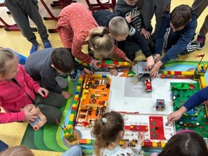 Uczniowie z klasy 1a układają zamek z klocków LEGO.