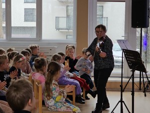 Nauczycielka Szkoły Muzycznej gra na skrzypcach podczas wizyty dzieci z zerówek w Szkole Muzycznej.