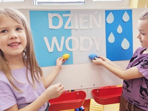 Dwójka dzieci z oddziału przedszkolnego (zerówka 03) prezentują planszę z napisem "Dzień Wody".