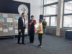 Dyrektor szkoły p. Piotr Kloczkowski wraz z bibliotekarką p. Moniką Młyńską wręczają nagrodę uczniowi, który wziął udział w szkolnym konkursie bibliotecznym.
