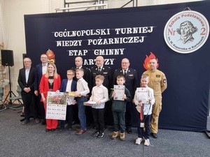 Laureaci gminnego etapu Ogólnopolskiego Turnieju Wiedzy Pożarniczej w kategorii klas 1 - 4 wraz z komisją konkursową prezentują się do zdjęcia.