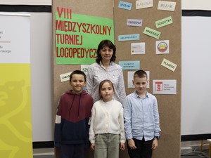 Nauczycielka logopedii p. Żanetta Walaszkowska oraz trójka uczniów prezentuje się do zdjęcia podczas VIII Międzyszkolnego Turnieju Logopedycznego "Szumiące Zabawy" w Pomorskiej Bibliotece Pedagogicznej w Gdańsku.