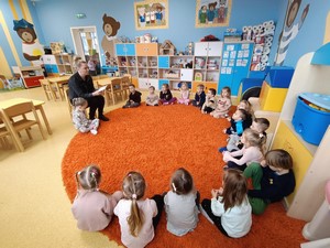 Mama dziecka z oddziału przedszkolnego (4 – latki) czyta opowiadanie dzieciom z oddziału przedszkolnego.