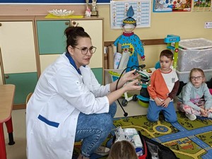 Pielęgniarka p. Alicja Labuda mama Sylwii z grupy 02 siedzi w oddziale 02 i opowiada dzieciom o swojej pracy.